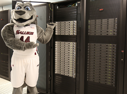 SIU Saluki mascot Grey Dog stands next to
                        the SIU IT Big Dog high performance computing
                        cluster.